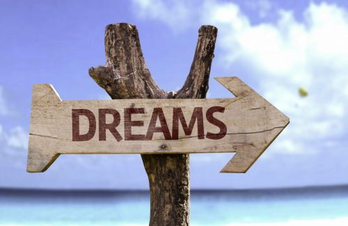 Dreams,Wooden,Sign,With,A,Beach,On,Background Ein Wegweiser zu Deinen Träumen