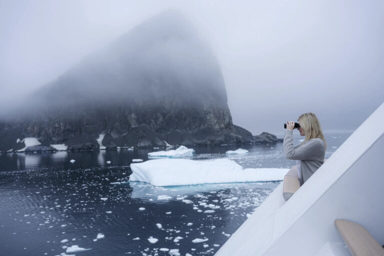 Frau mit Fernglas in Alaska Eisberge
