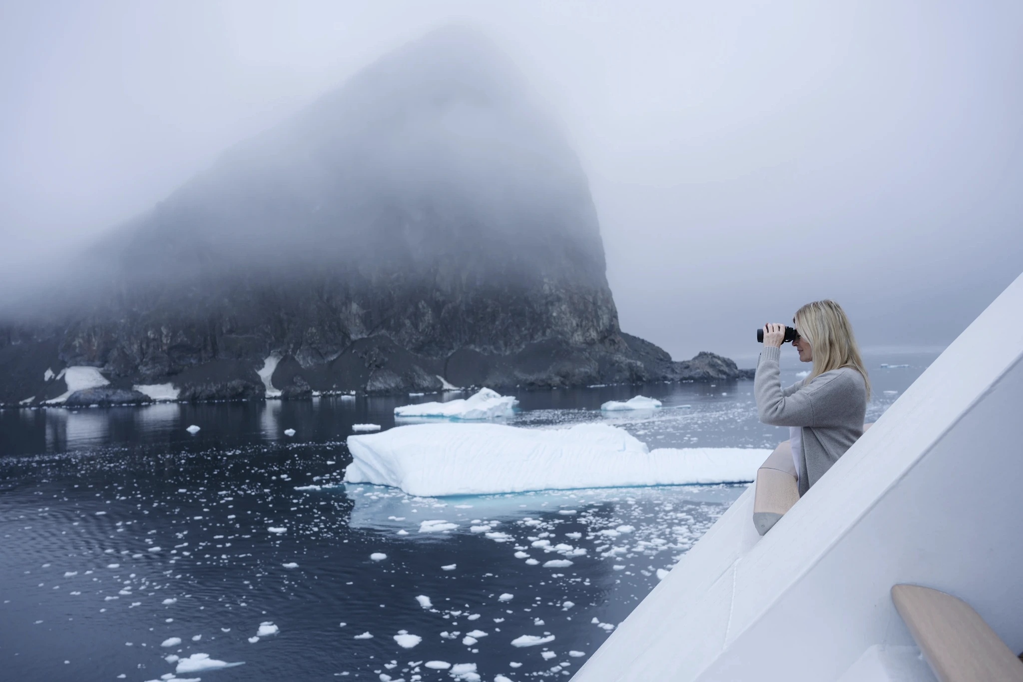 Frau mit Fernglas in Alaska Eisberge
