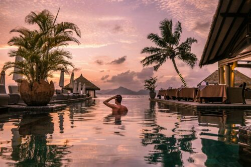 Seychellen Infinitypool Luxus Traumurlaub Luxuriöser Infinity-Pool mit Blick auf das türkisfarbene Meer der Seychellen, umgeben von tropischer Natur. Ein exklusiver Traumurlaub für Genießer, die Ruhe, Erholung und erstklassigen Komfort in einer paradiesischen Umgebung suchen.