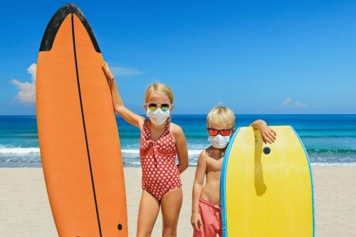 Young,Surfer,Kids,With,Surf,Boards,Wear,Protective,Mask,On shutterstock 1722126664 scaled 500x0 c default