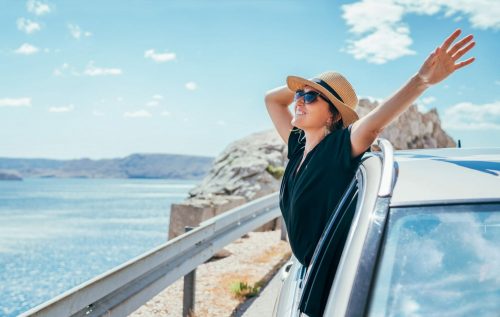 Cheerful,Woman,Portrait,Enjoying,The,Seaside,Road,Trip.,Dressed,A shutterstock 1814035103 scaled 500x0 c default